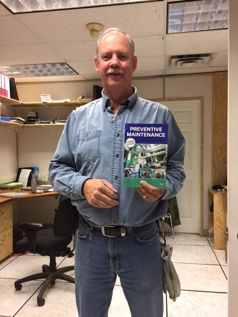 Photo of Doug showing his book, "Preventive Maintenance"